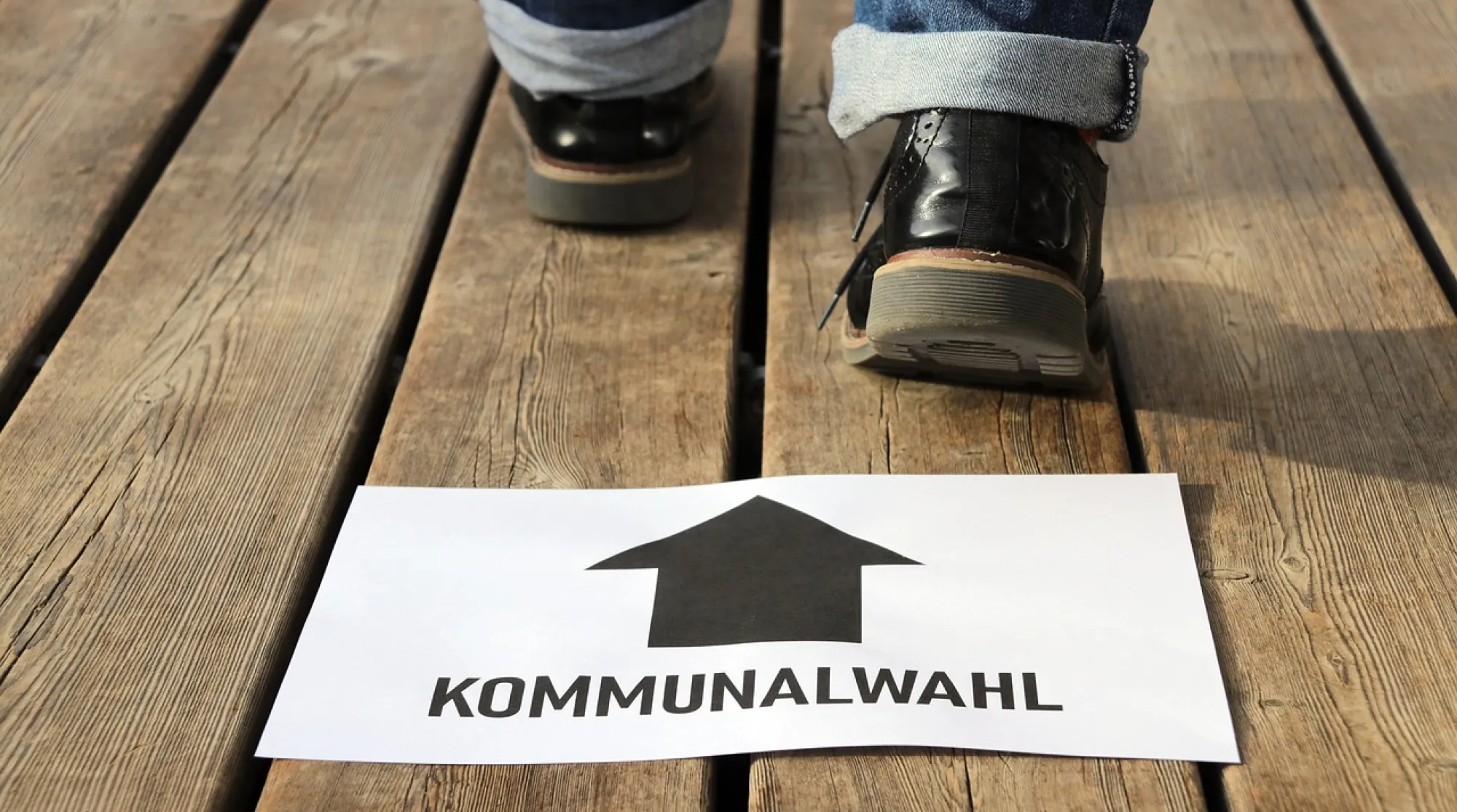 Pfeil mit Hinweisschild zur Kommunalwahl und Fußabrücken